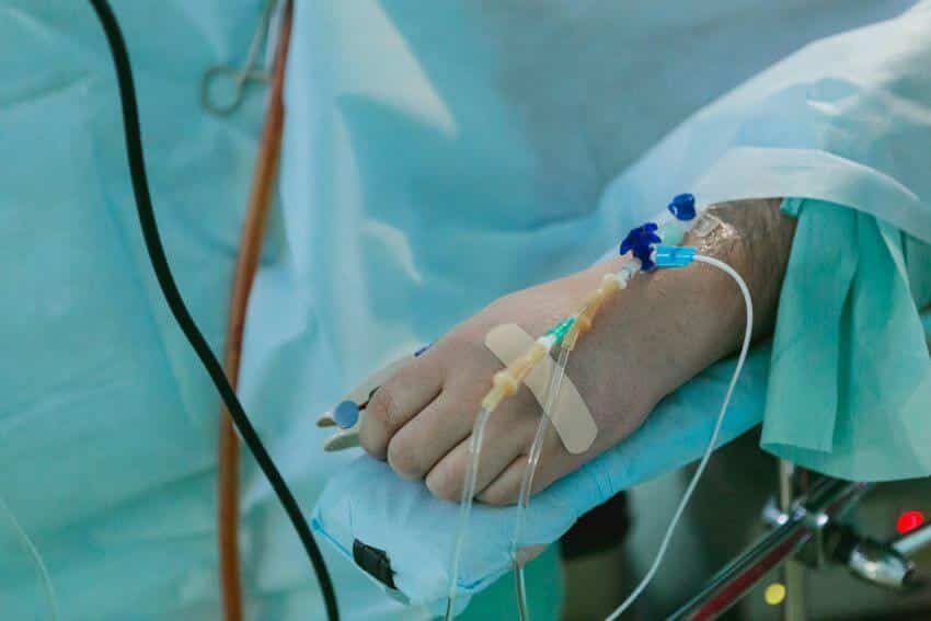 Sick person in hospital bed with tubes