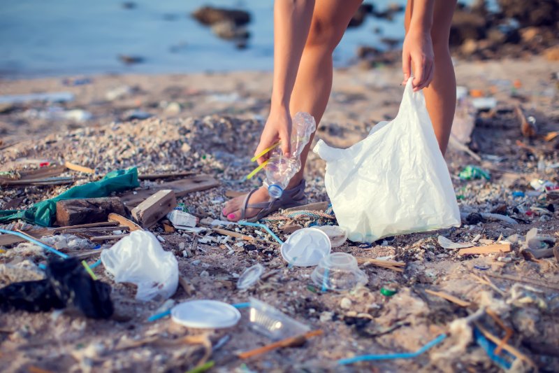 Woman collecting garbage on the beach