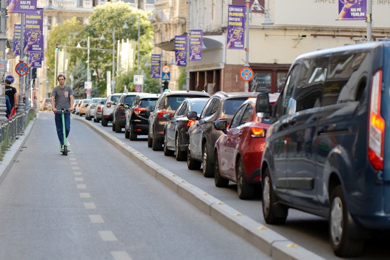 Man in electric scooter vs cars in traffic