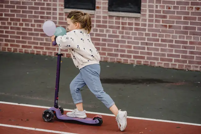 a small girl on a scooter