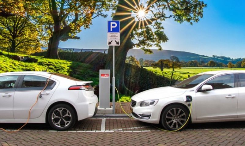 two white electric cars charging