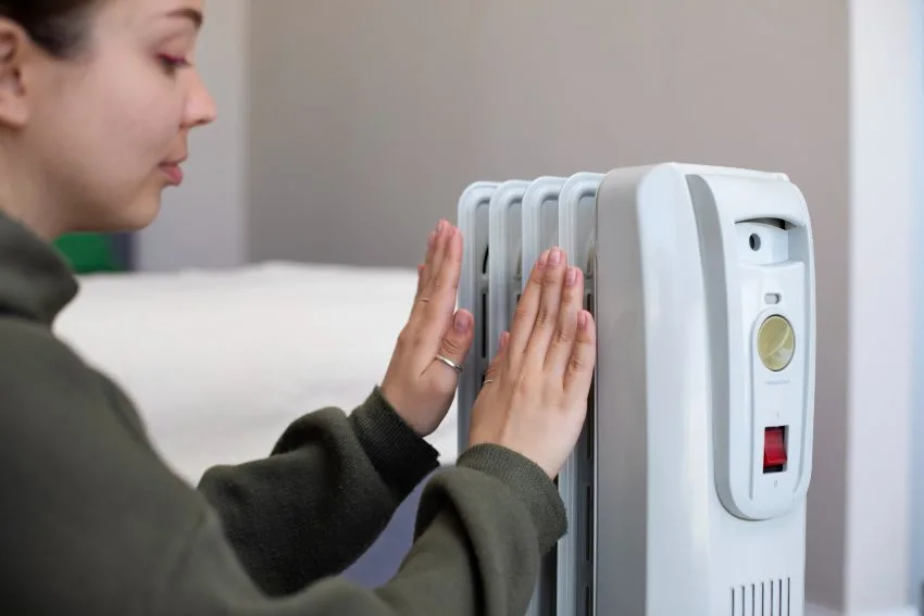 6 Best Eco-Friendly Space Heaters | Energy Efficient Options 8 woman heating her hands