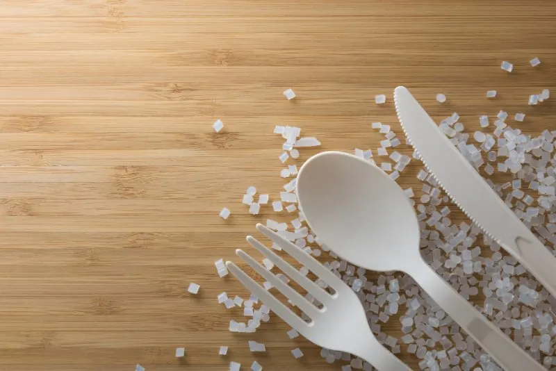 plastic pellets, spoon and fork, sugar on table