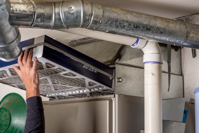 Man replacing a filter in a furnace