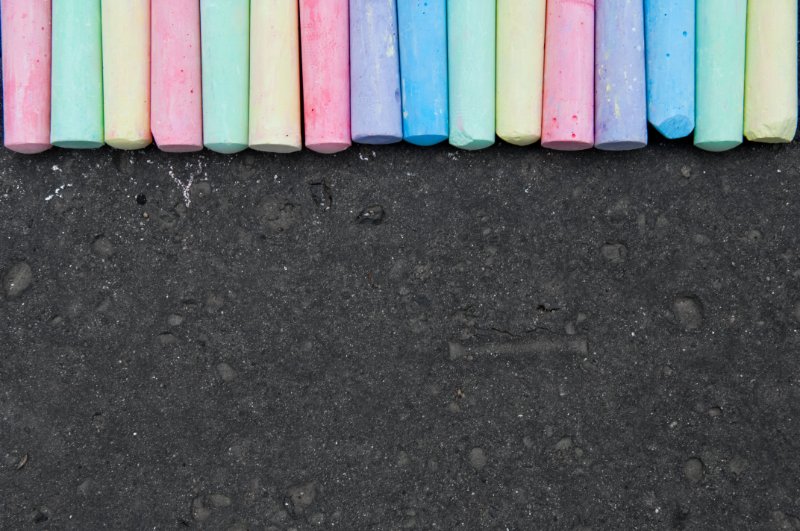 Colorful pastel sidewalk chalk placed on road