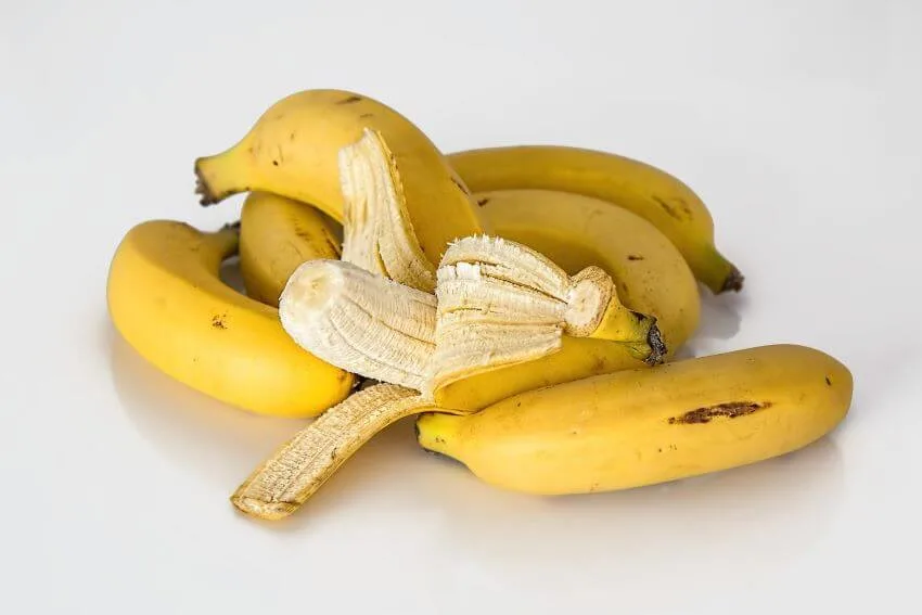 Bananas and peeled banana placed on a table