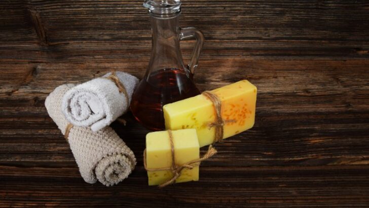 2 hand towel, jar with oil, 2 soaps placed on a table