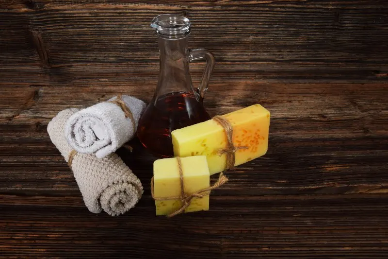 2 hand towel, jar with oil, 2 soaps placed on a table