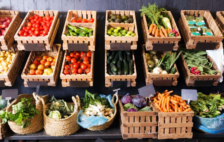 View on rustic containers with various fresh vegetables and fruits
