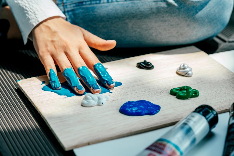 Artist using hand while adding colors to the palette