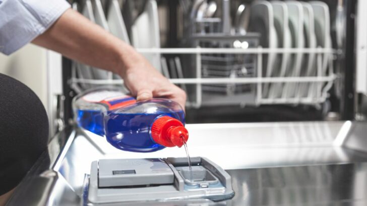 Close-up hand filling dishwasher with gloss liquid into the dishwasher box