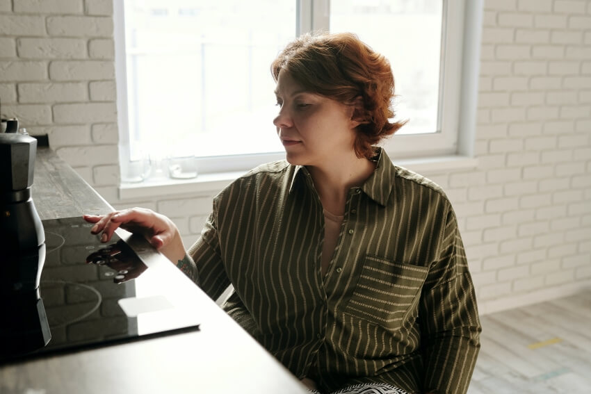 Woman Touching an Electric Stove