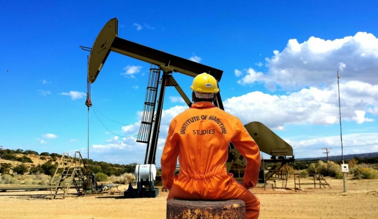 A petroleum engineer surveying an oil drilling rig