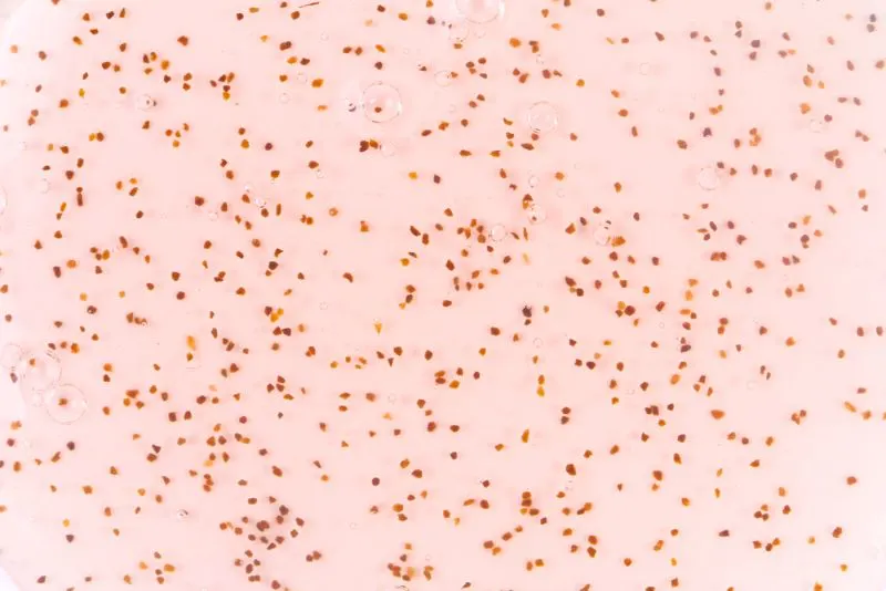 Background of shampoo containing red plastic microbeads