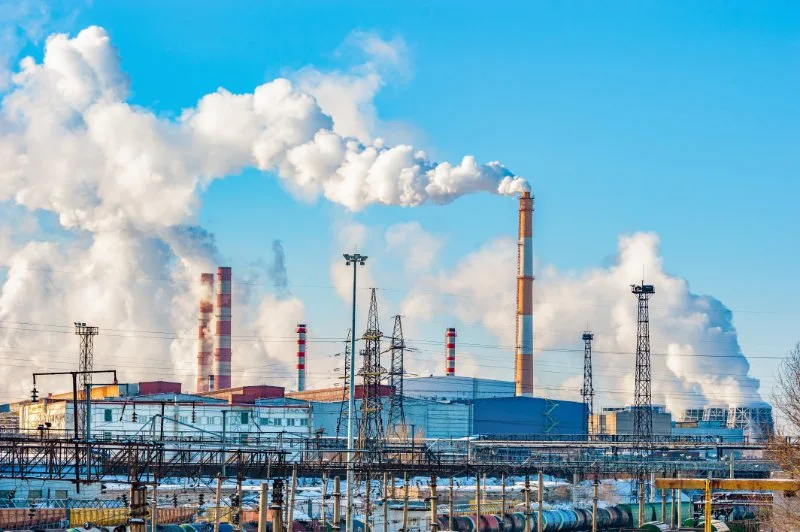 Factories emitting smoke into the sky through chimney