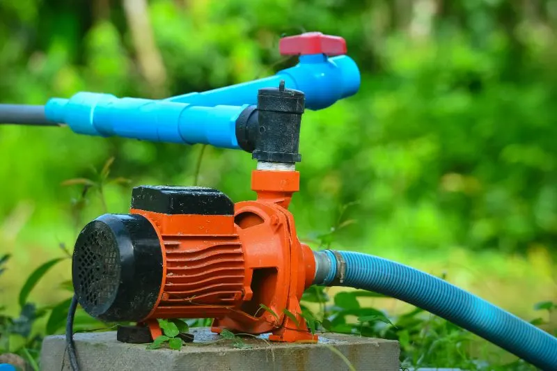 orange water pump in a garden
