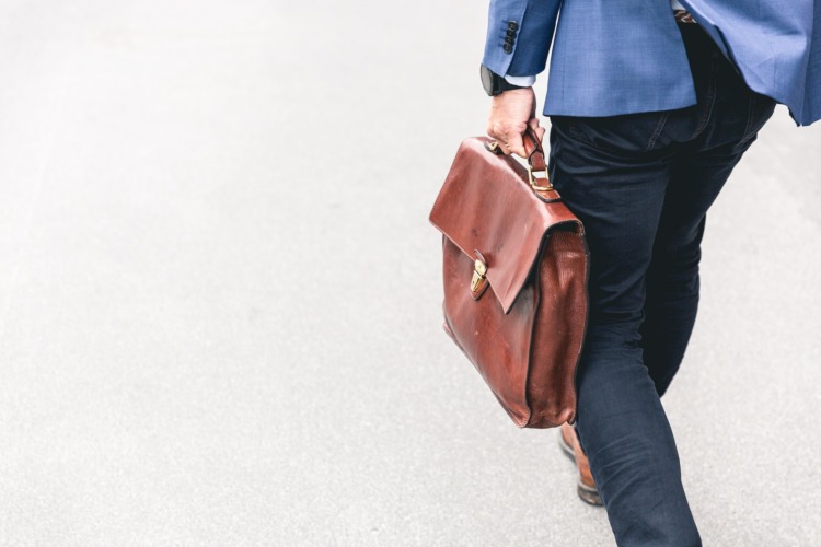 an going to work carrying an attache case bag