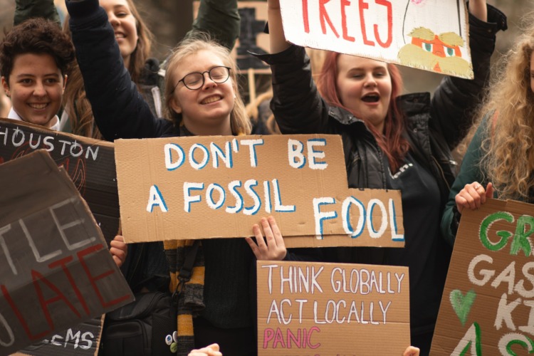 Fossil fuel protestors holding cardboards with words