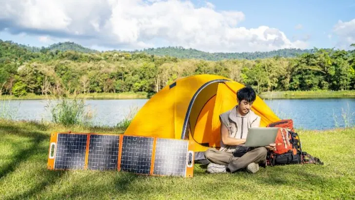 Hand male plug in portable solar panel charging laptop computer