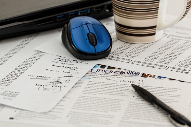 Table filled with tax forms and pen