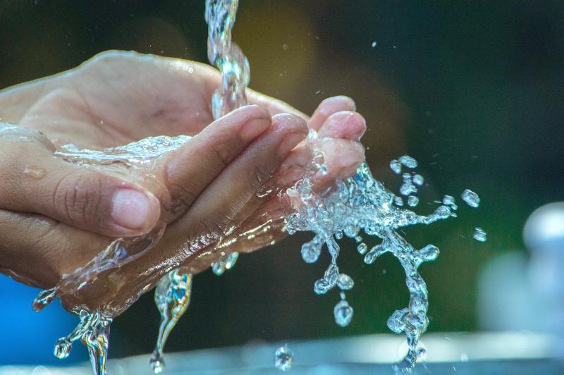 How Does Saving Water Help Climate Change? Hands under running faucet