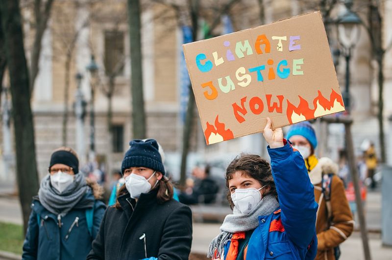 Protester holding a sign with Climate Justice Now message at a Global Climate Strike