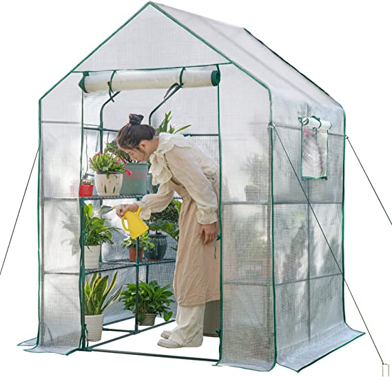 woman watering her plants inside a greenhouse