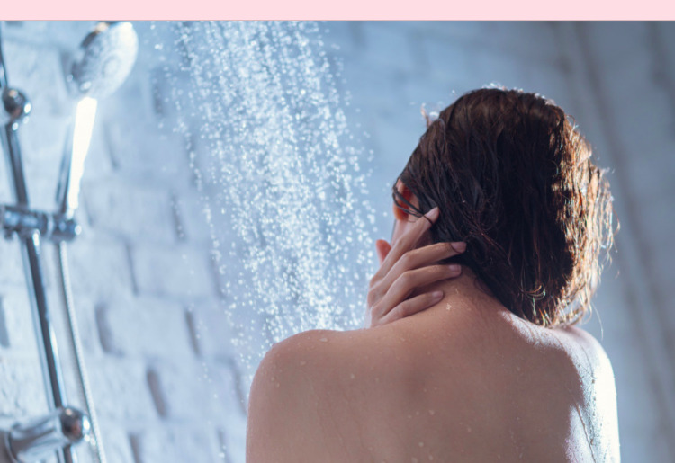 A person enjoying a refreshing outdoor shower in a tropical paradise.