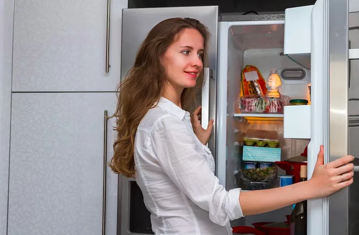 woman opening fridge