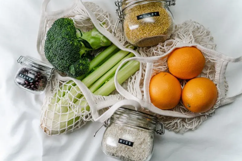 fruits in a mesh bag and glass jars