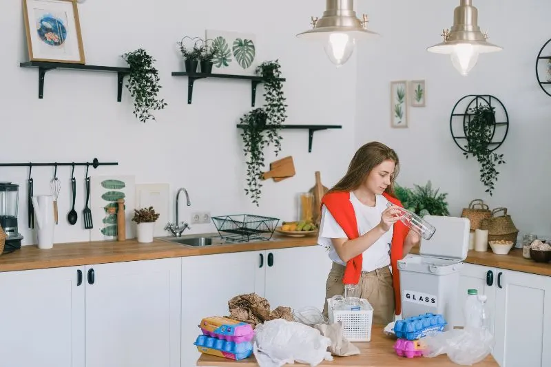 The Environmental Impact of Plastic Pollution: Is It Too Late to Solve? 7 young woman utilizing wastes in modern kitchen
