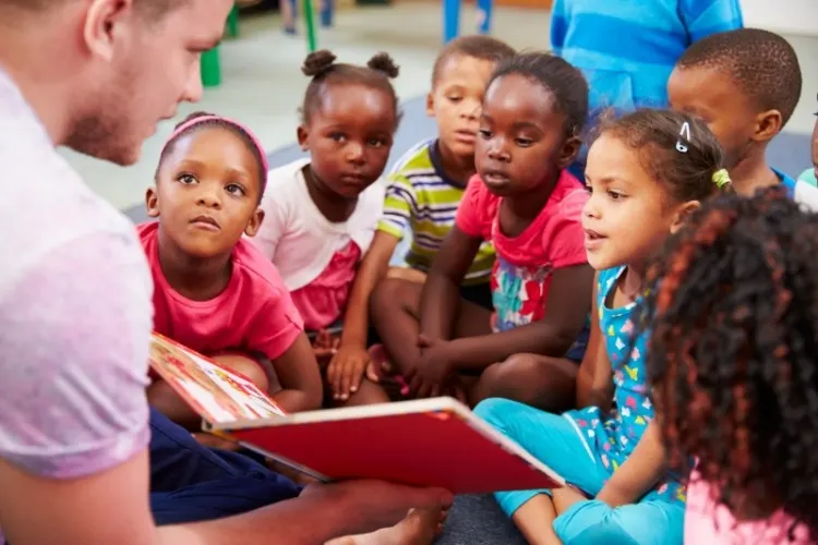 Volunteer teacher reading to a class of preschool kids