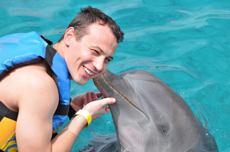 Dolphin kiss man in blue clean caribbean water