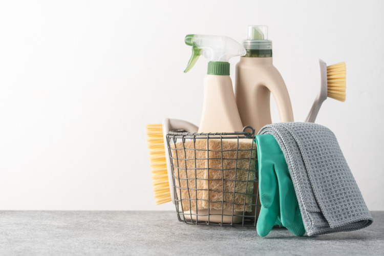 Brushes, sponges, rubber gloves and natural cleaning products in the basket. Eco-friendly cleaning products