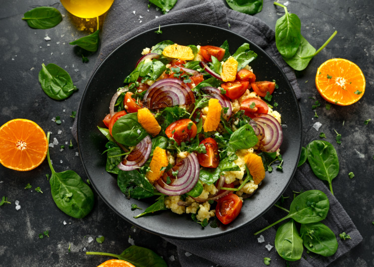 Vegetable Millet salad with red onion, cherry tomatoes, spinach, tangerine and clementine dressing. healthy food