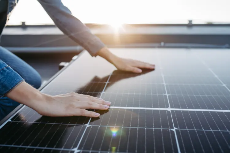 Ultimate Guide to Maximize the Efficiency of a Solar Panel 7 Close up of woman touching solar panels on the roof.
