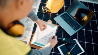 Solar panels, planning and engineering hands with technology, checklist or insurance for installation. Energy saving, electricity and power technician with laptop, tools and maintenance management