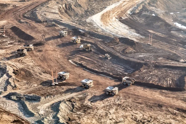 Aerial view of giant dump trucks collecting newly mined Oilsand from Athabasca Tar sand site being processed in local Petrochemical refineries Alberta travel