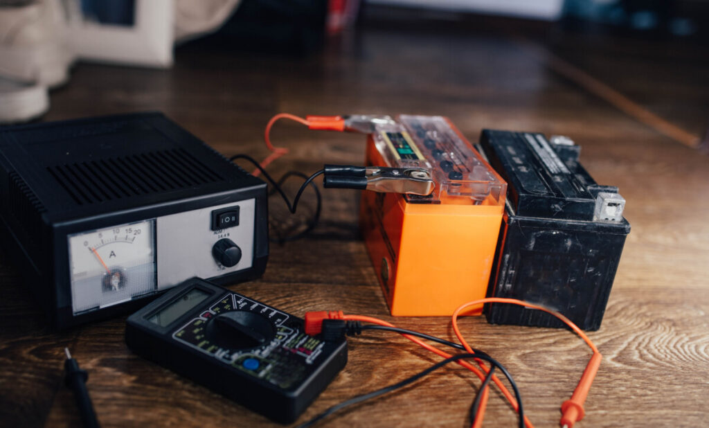 Solar Lead-Acid Batteries: Types, Sizing, Maintenance, and Safety 4 Technician connecting a charger to an AGM lead-acid battery