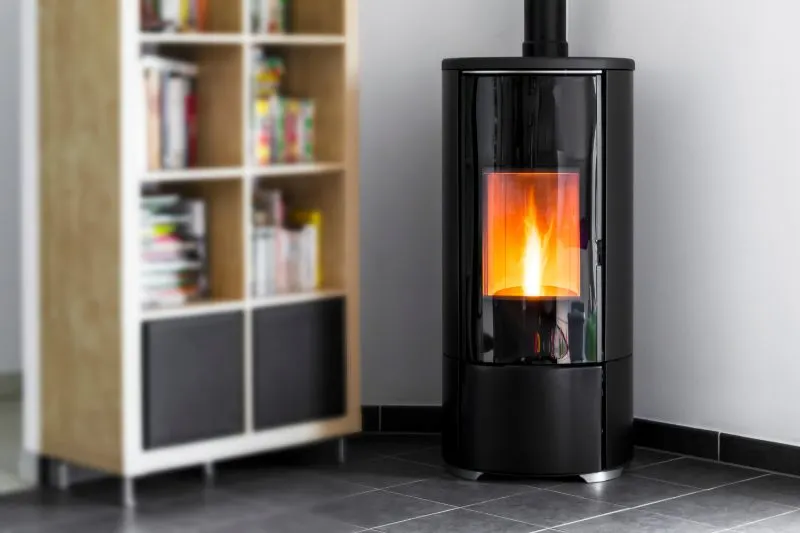 Modern domestic pellet stove, granules stove with flames and library