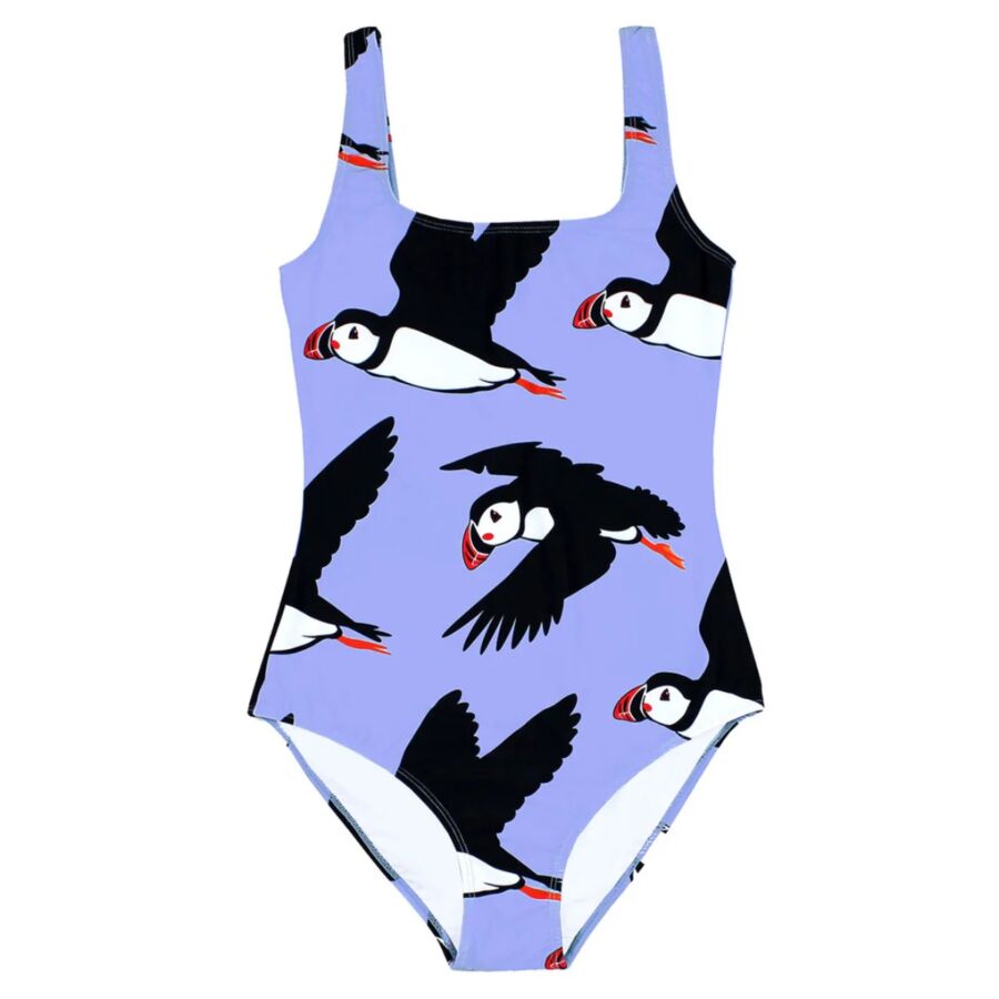 12 Best Sustainable Swimwear Picks for 2026 16 Model showcases a Batoko swimsuit featuring a colorful puffin print against a vibrant background.