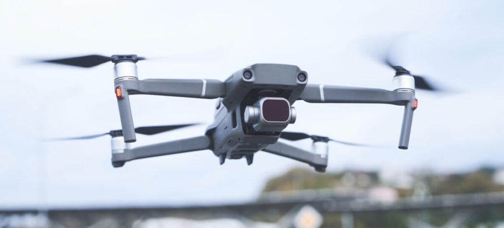 Wildlife Photography Guide: Ethical Camera Settings, Gear, and Fieldcraft 7 Drone hovers in the sky, recording a close-up video of the urban landscape below, highlighting city features.