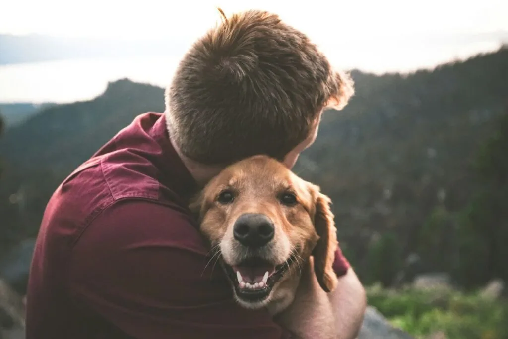 Man hugging a brown dog