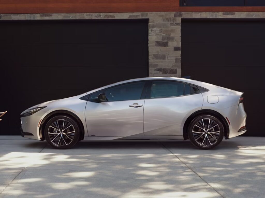 10 Most Eco-Friendly Cars for Different Lifestyles in 2026 15 Parked Toyota Prius LE hybrid in front of a garage, highlighting its eco-friendly design and compact size.