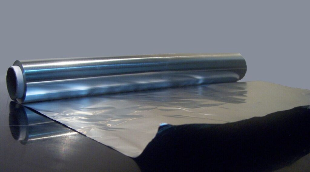 Is Aluminum Foil Recyclable? How to Recycle It Correctly 13 Roll of aluminum foil on a table, highlighting its smooth, reflective surface and typical kitchen packaging.