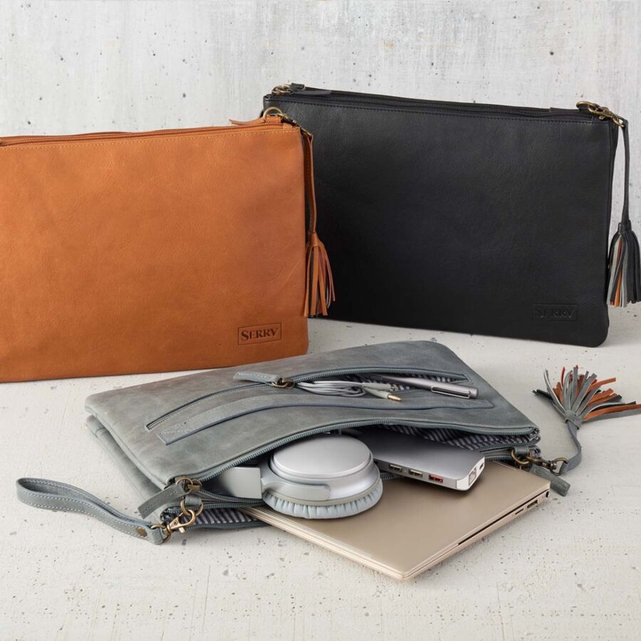 10 Best Fair Trade Handbags for 2026 16 Two camel tan leather purses displayed with a laptop and a cell phone, showcasing the Ankita Tech Bag design.
