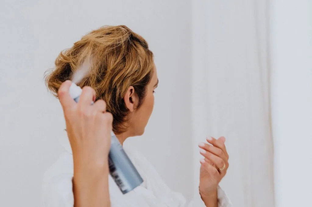 Is Dry Shampoo Bad for the Environment? 2 Spraying a woman's hair