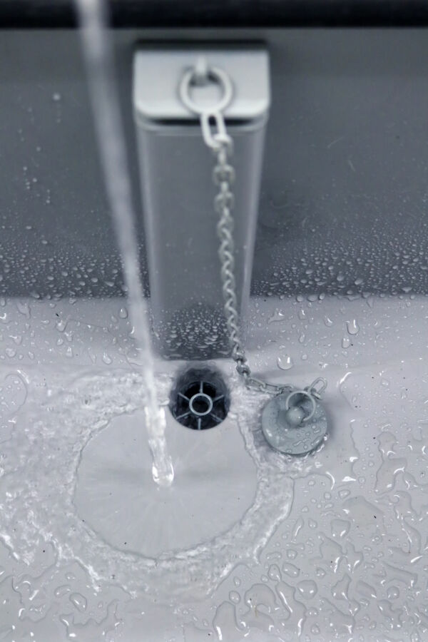 Is Water a Renewable Resource? Yes—But It Isn’t Unlimited 12 Close-up of a sink with water flowing from the tap into the drain pipe.