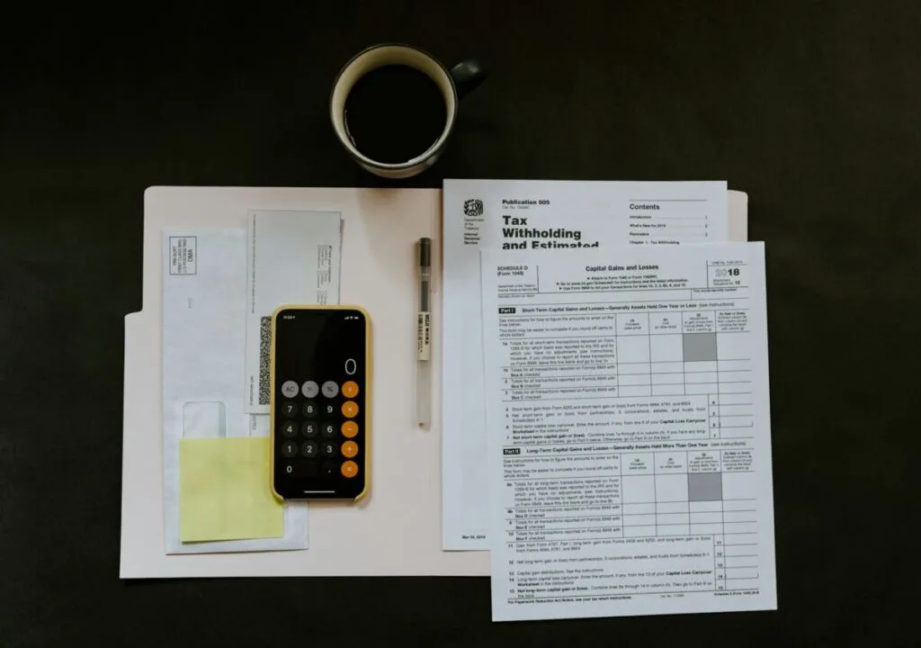 Carbon Inequality: How the Richest 1% Drive Climate Change 1 Tax forms, a calculator app, pen and coffee arranged on a desk