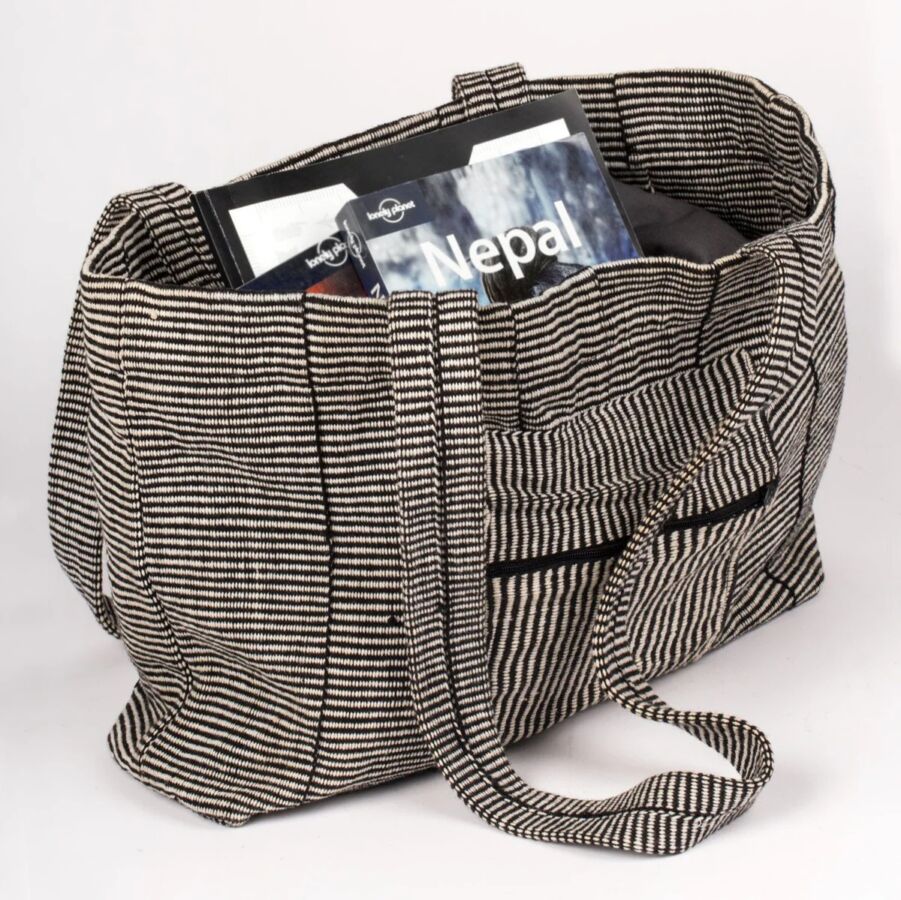 10 Best Fair Trade Handbags for 2026 14 Black and white striped tote bag filled with books, showcasing a stylish and functional design for everyday use.
